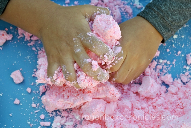 child mixing raspberry foam dough